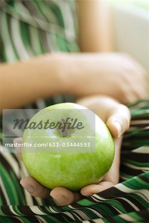 Femme tenant une pomme verte, recadrée