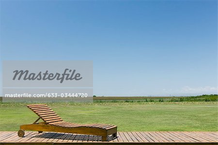 Lounge chair on deck in rural landscape