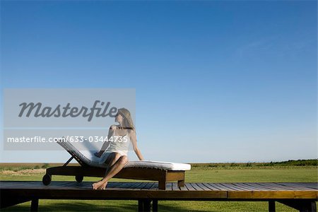 Woman relaxing on lounge chair outdoors