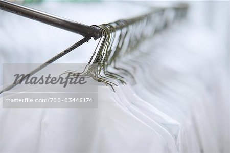 Chemises blanches suspendus sur des cintres