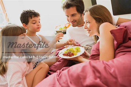 Family having breakfast in bed