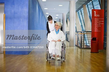 Vieille femme dans un fauteuil roulant et une infirmière