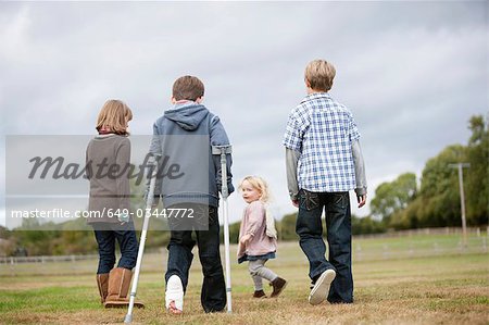 Boy on crutches with other children