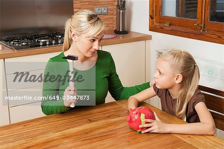 Mutter und Tochter knacken ein Sparschwein