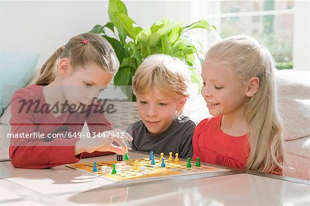Three children playing a board game