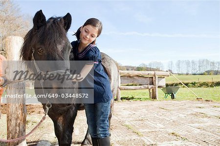 Fille peignant un poney