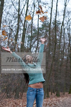 Woman Throwing Autumn Leaves in the Air