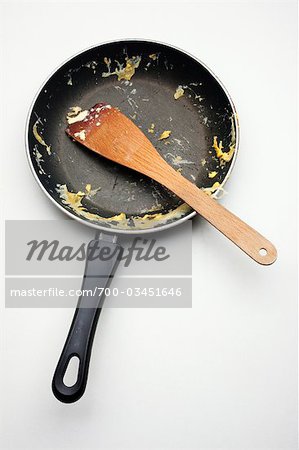 Sale oeuf poêle avec une spatule en bois