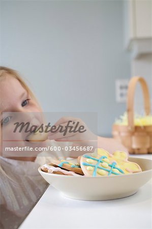 Kleine Mädchen essen Ostern Cookies