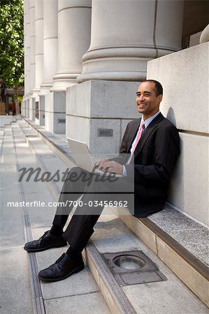 Businessman Using Laptop on Stairs