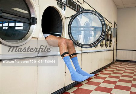 Homme étendu Clothes Dryer en laverie automatique