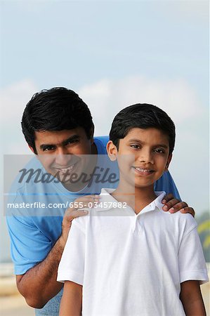 Father holding sons shoulders and smiling