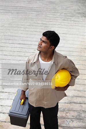 Mann, der Bau-Hut und Werkzeug Kasten Wegsehen