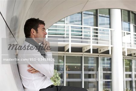 Thoughtful businessman standing in archway, side view