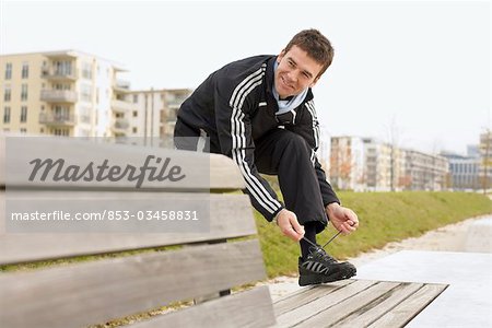 Jogger serrant la chaussure de course, format horizontal