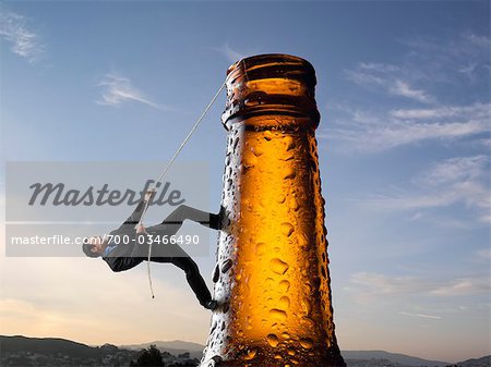 Homme d'affaires escalade bouteille de bière