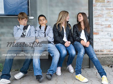 Jungen und Mädchen auf Bank