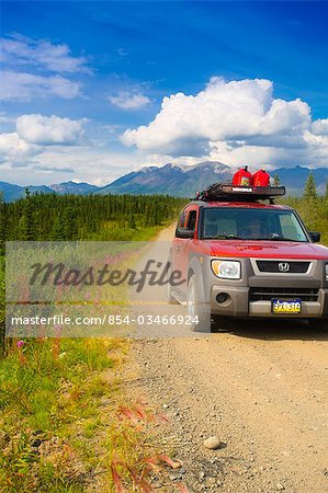 Car travelling on Nabesna Road in Wrangell Saint Elias National Park with the  Mentasta Mountains in the background, Southcentral Alaska, Summer