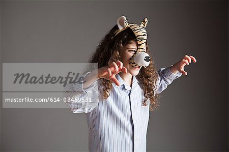 Jeune fille portant le masque de tigre, rugissant