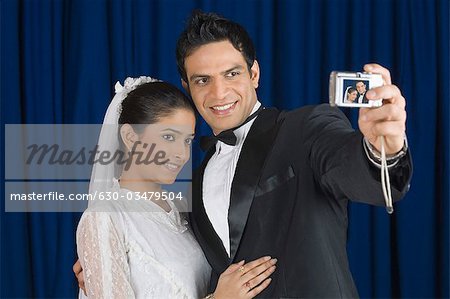 Gros plan d'un couple de jeunes mariés se photographier