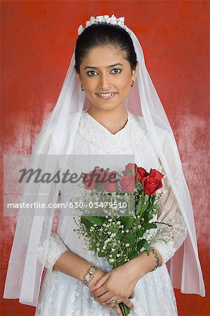 Portrait of a newlywed bride holding a bouquet of flowers and smiling