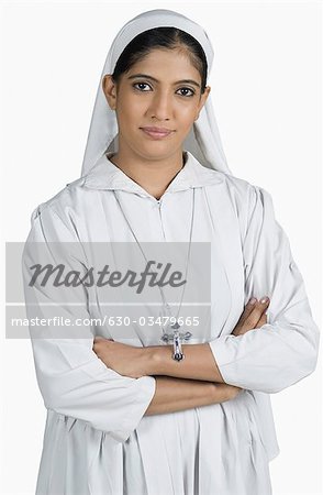 Portrait d'une religieuse debout avec les bras croisés