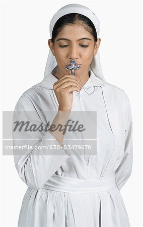 Nahaufnahme einer Nonne küssen das Kruzifix
