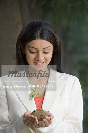 Gros plan d'une femme tenant une plante