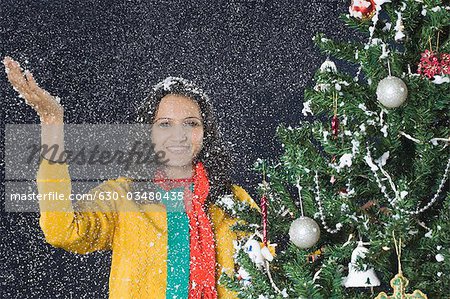 Woman standing in snow near a Christmas tree