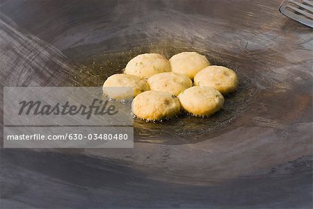 Close-up of aloo tikkis being fried on a griddle, Delhi, India