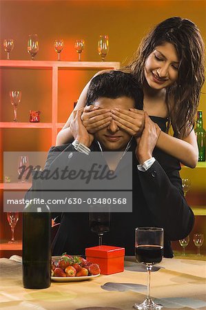 Frau für Augen ihres Freundes in einer bar