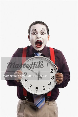 Close-up of a mime showing a clock