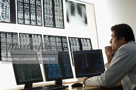 Médecin de sexe masculin examine un rapport de rayons x