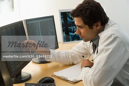Médecin de sexe masculin examine un rapport de rayons x