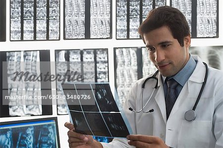 Male doctor examining an X-Ray report