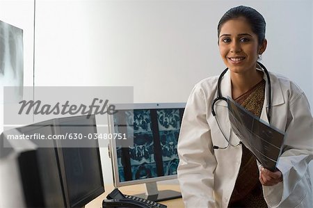 Portrait d'une femme médecin détenant un rapport aux rayons x et souriant