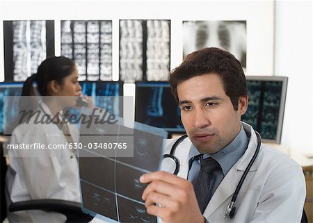 Männlichen Arzt untersucht einen Röntgen-Bericht
