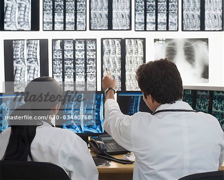 Femme médecin avec un médecin de sexe masculin examine un rapport de rayons x