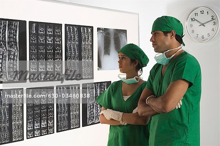 Weibliche Chirurg mit männlichen Chirurg untersuchen einen Röntgen-Bericht