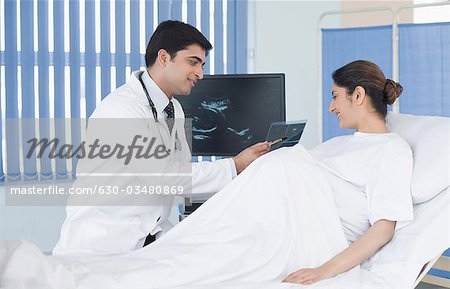 Männlichen Arzt mit Ultraschall auf schwangere Frau