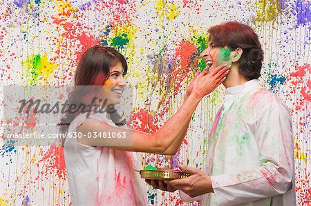 Woman applying colors on a man's face