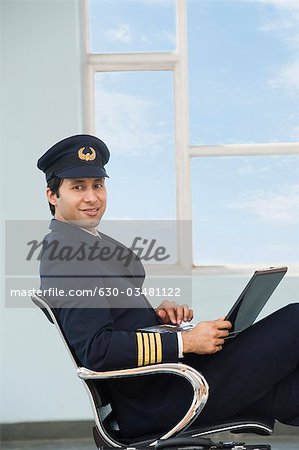 Pilot using a laptop at an airport