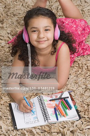 Girl listening to headphones and drawing a picture
