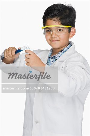 Boy in a lab coat experimenting with test tubes