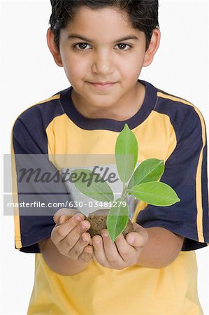 Portrait d'un garçon tenant une plante