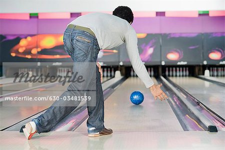 Young man playing ten pin bowling
