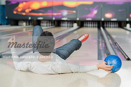 Young man falling in a bowling alley