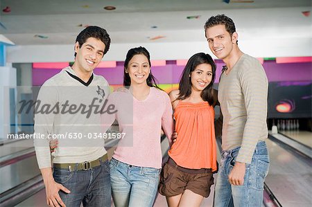 Deux jeunes couples dans une ruelle de bowling