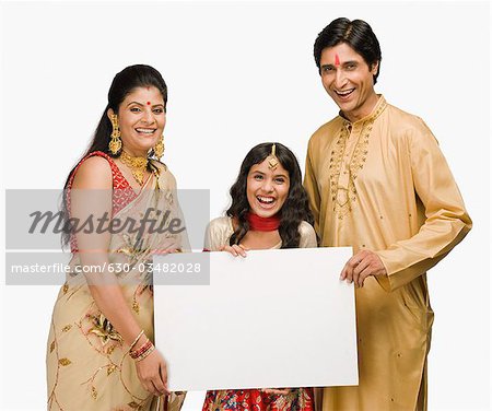 Portrait d'un couple avec leur fille tenant une pancarte