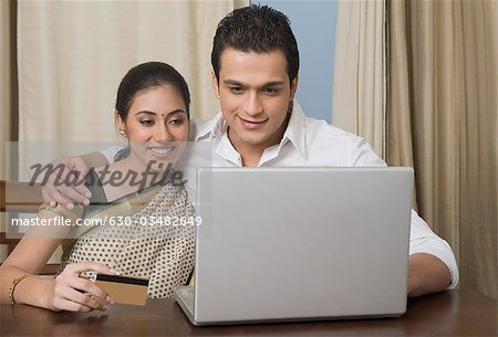 Couple doing home shopping on a laptop